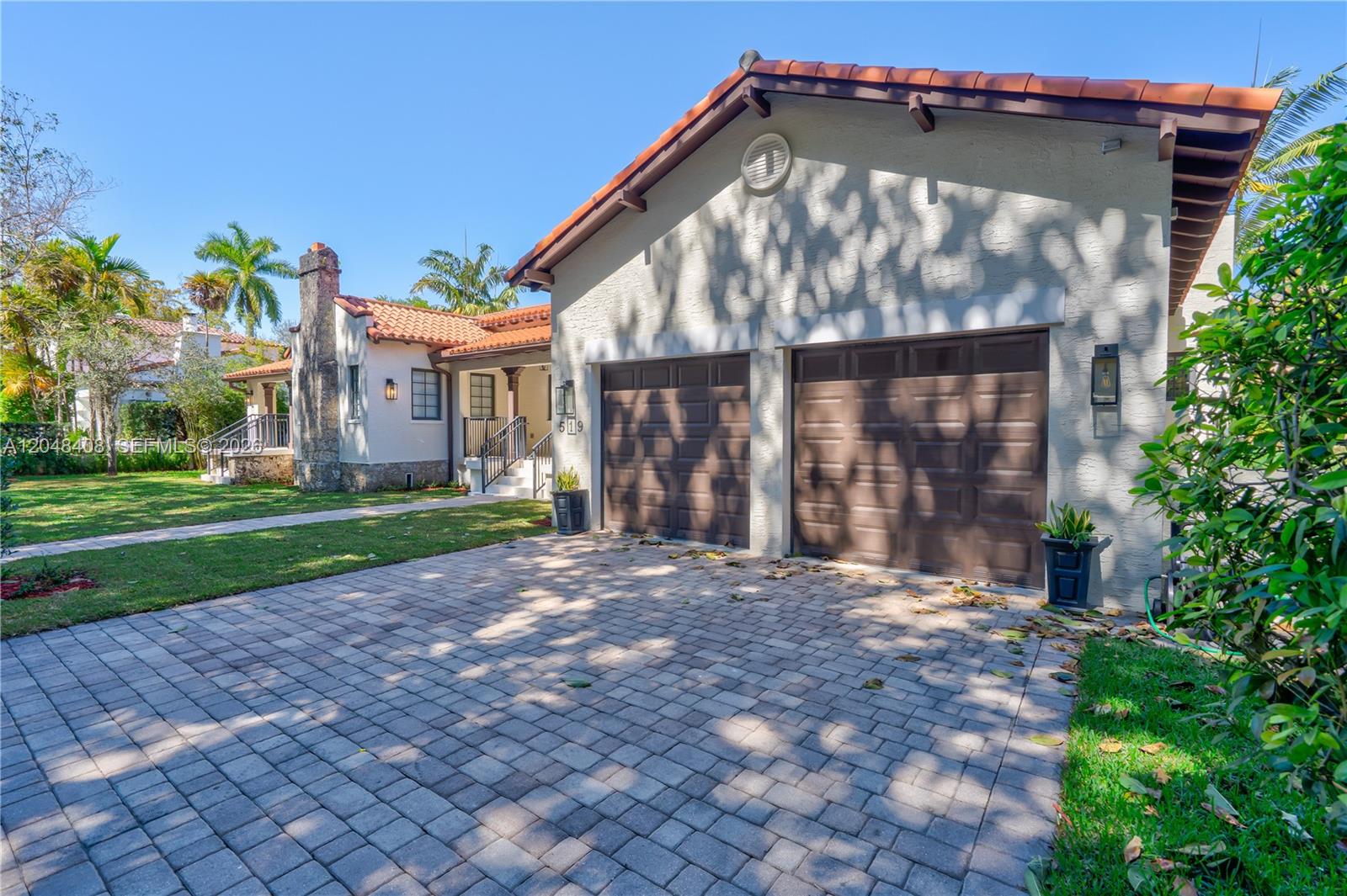 A single-story house with a two-car garage, tile roof, and a paved driveway — 519 Alhambra Cir, Coral Gables FL 33134, CORAL GABLES, FL