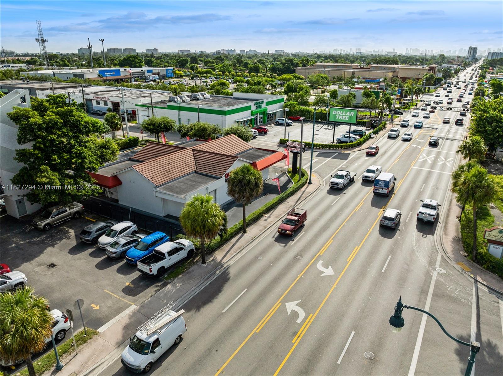 An aerial view shows a commercial building with a parking lot beside a busy road — 7101 SW 8th St, Miami FL 33144, MIAMI, FL