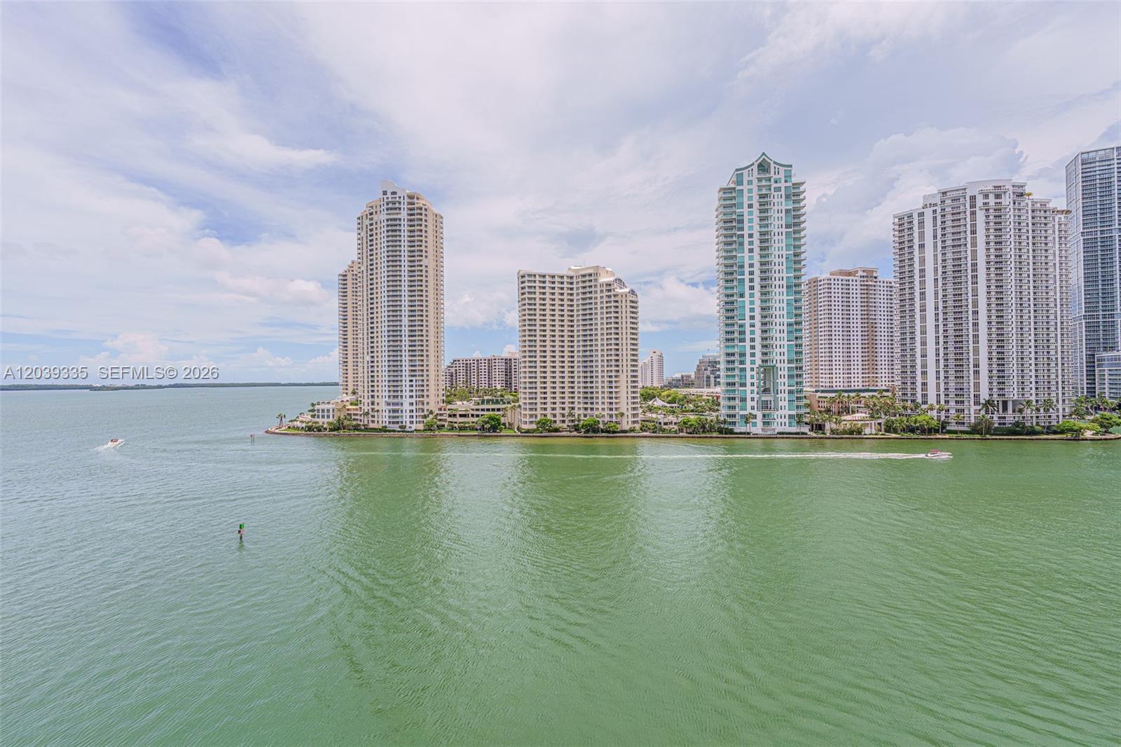 An aerial view shows several high-rise residential towers situated along a waterfront — 335 S Biscayne Blvd # 1009, Miami FL 33131, MIAMI, FL