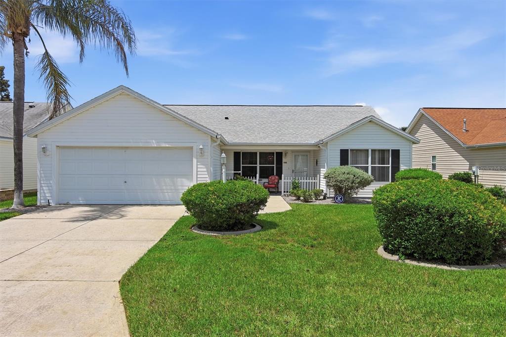 A single-story house with white siding, a two-car garage, and a manicured front lawn — 3425 CARBONDALE COURT, THE VILLAGES, FL