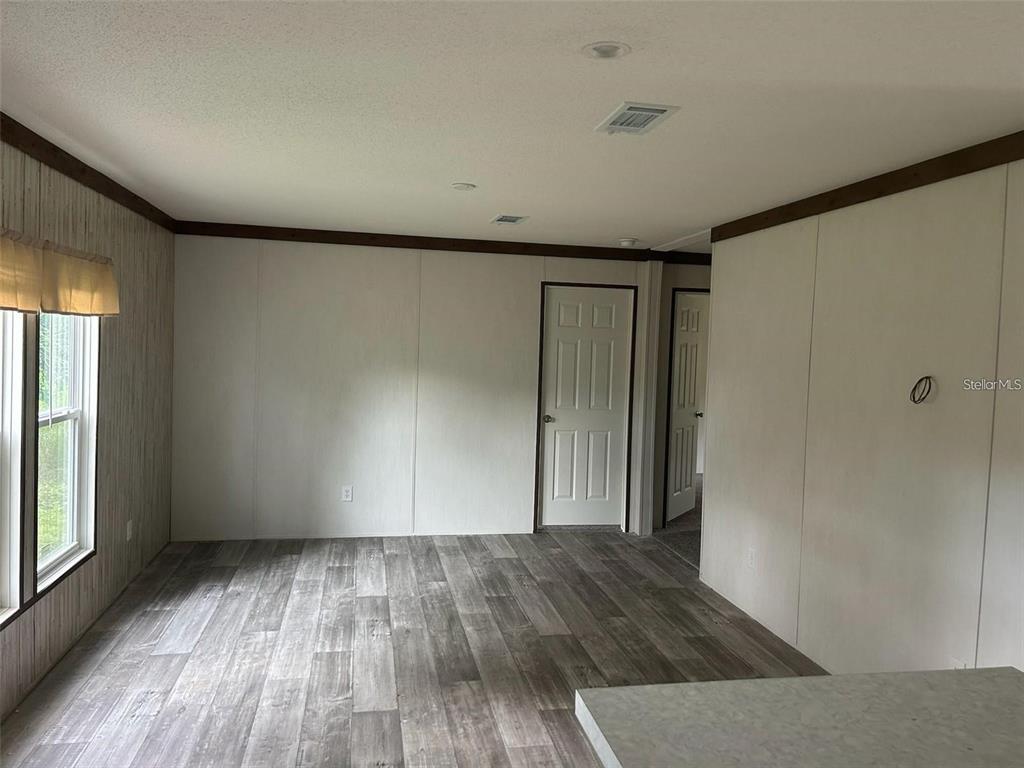 A room with light-colored walls, wood-look flooring, and two interior doors — 3548 VALLEY TRAIL, LAKELAND, FL