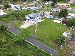 An aerial view shows a two-story house situated on a large, grassy lot — 927 ANTON RUIZ UNIT KM 27.7, HUMACAO, PR