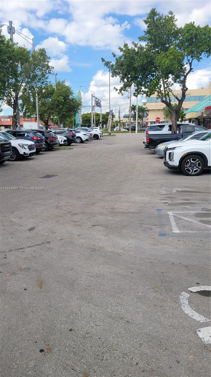 A parking lot with several parked cars and trees under a blue sky — 1169 W 37th St # 1181, Hialeah FL 33012, HIALEAH, FL