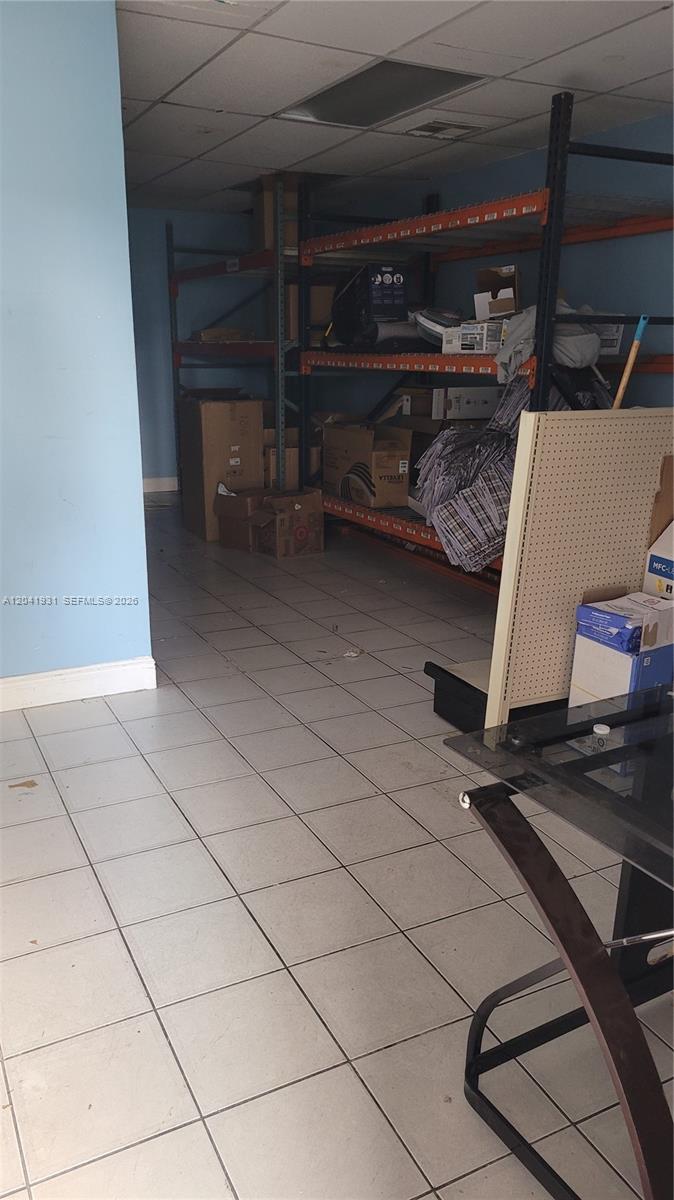 A storage room features industrial metal shelving units, tiled flooring, and light blue walls — 1169 W 37th St # 1181, Hialeah FL 33012, HIALEAH, FL