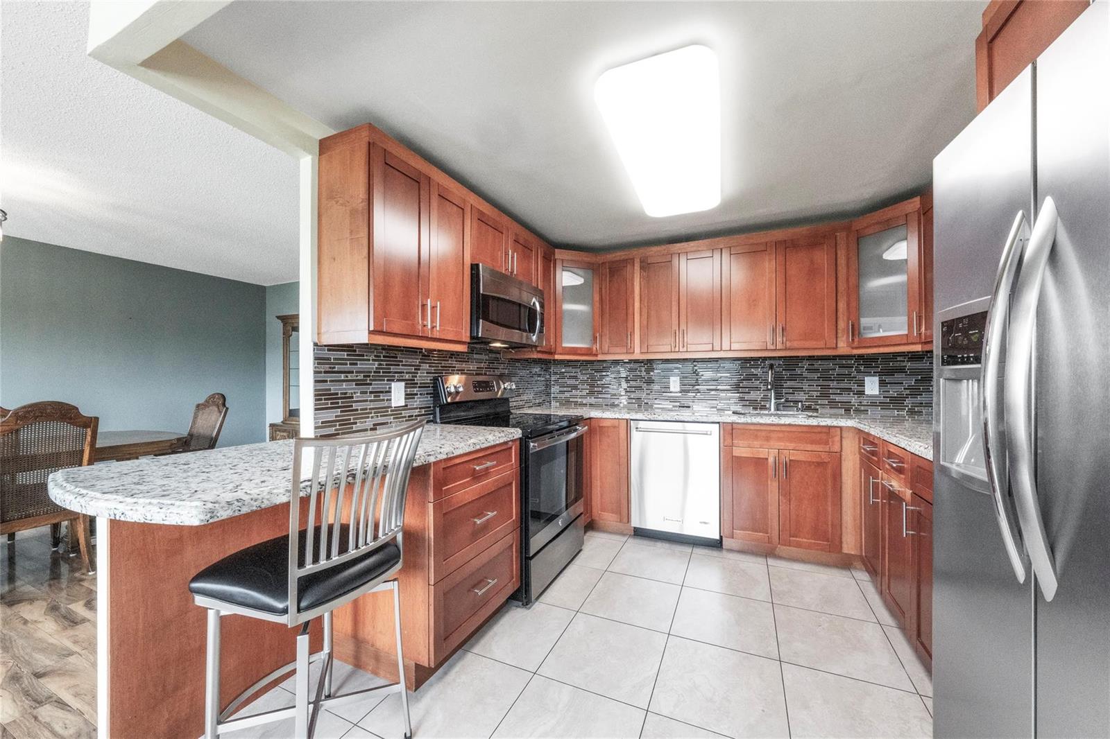 A kitchen with cherry wood cabinets, granite countertops, stainless steel appliances, and a breakfast bar — 404 Richmond A # 404, Deerfield Beach FL 33442, DEERFIELD BEACH, FL