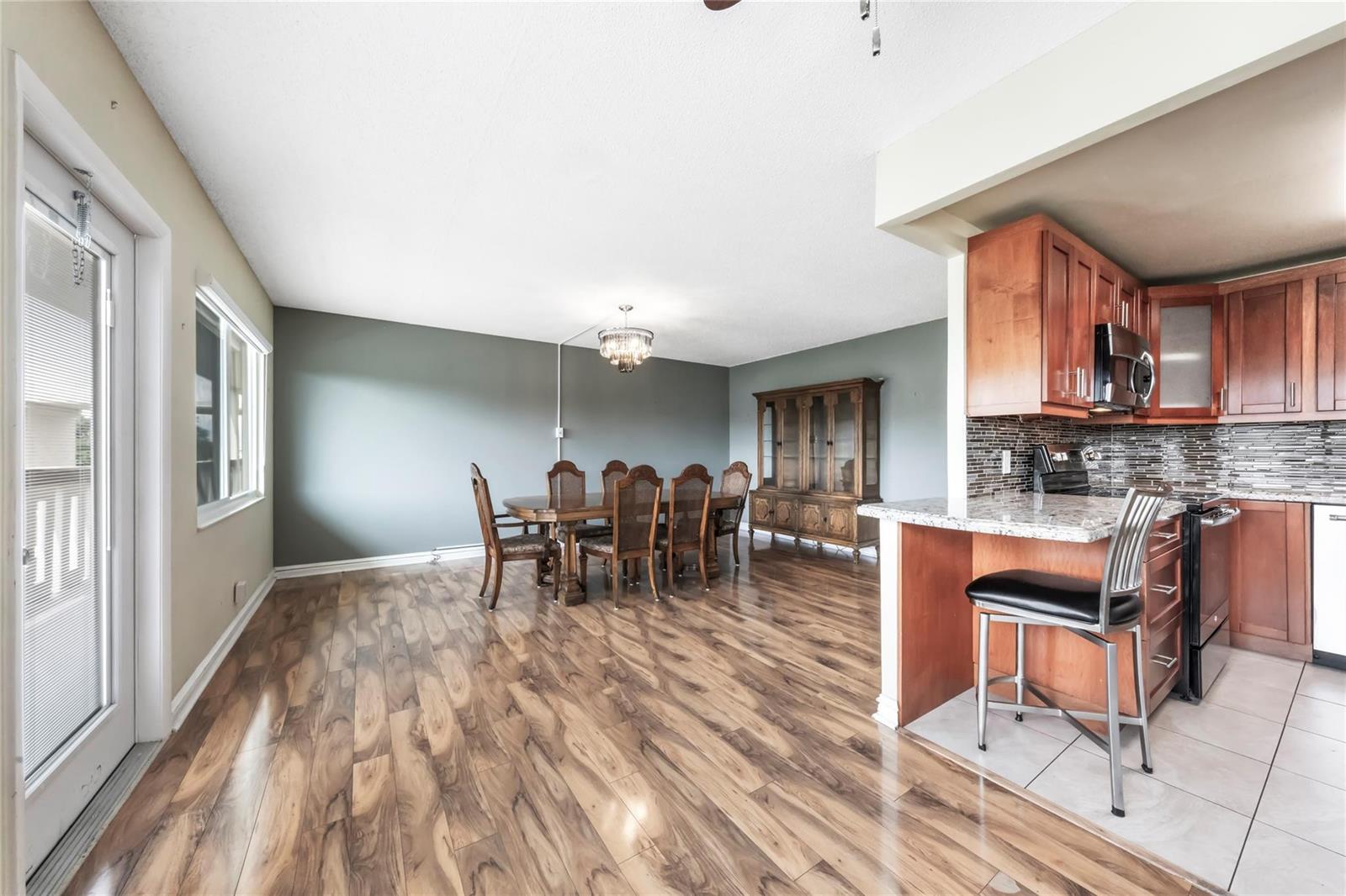A dining area with wood flooring and a kitchen featuring wood cabinets and granite countertops — 404 Richmond A # 404, Deerfield Beach FL 33442, DEERFIELD BEACH, FL