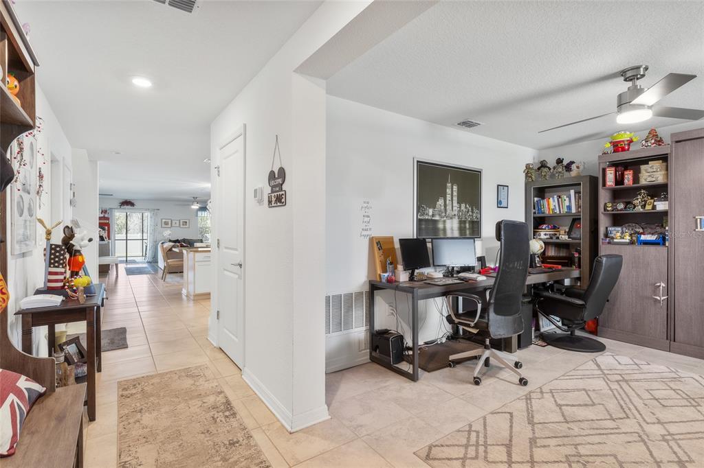 A home office with two desks and a computer setup sits adjacent to a hallway — 4382 FINCH LANE, KISSIMMEE, FL
