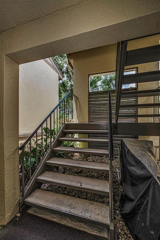 An outdoor staircase with metal railings leads to an upper level next to a building — 124 WOODLAKE WYNDE UNIT 0, OLDSMAR, FL