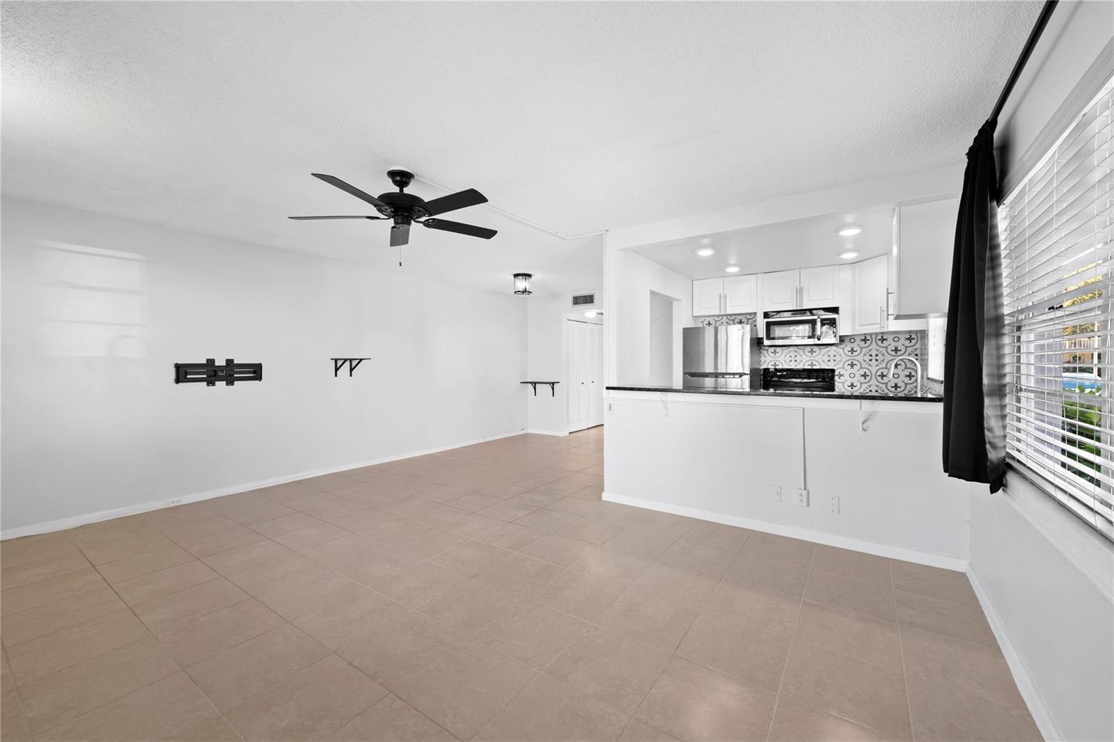 An open-concept living area with tile flooring, a ceiling fan, and an adjacent kitchen — 28 Prescott B # 28, Deerfield Beach FL 33442, DEERFIELD BEACH, FL