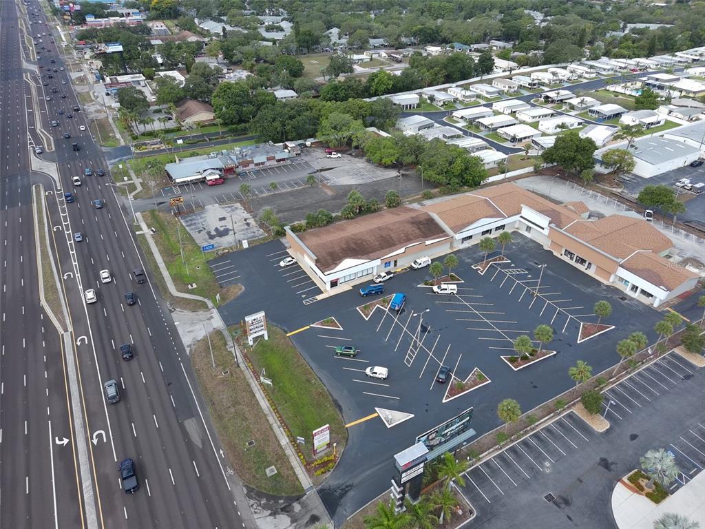 An aerial view shows a commercial building with a large parking lot next to a highway — 39930 US HIGHWAY 19 N, TARPON SPRINGS, FL