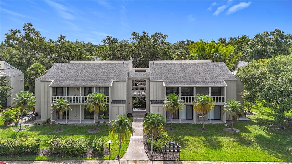 An exterior view of a two-story apartment building with a central walkway and palm trees — 2220 BAHIA VISTA STREET UNIT G5, SARASOTA, FL