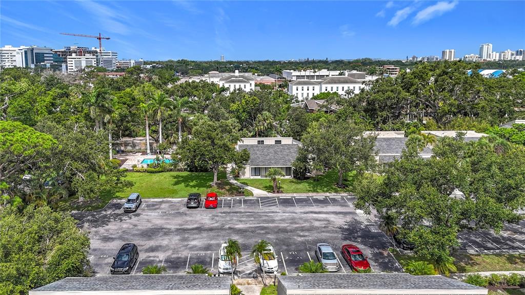 An aerial view shows a parking lot in front of a building surrounded by trees — 2220 BAHIA VISTA STREET UNIT G5, SARASOTA, FL