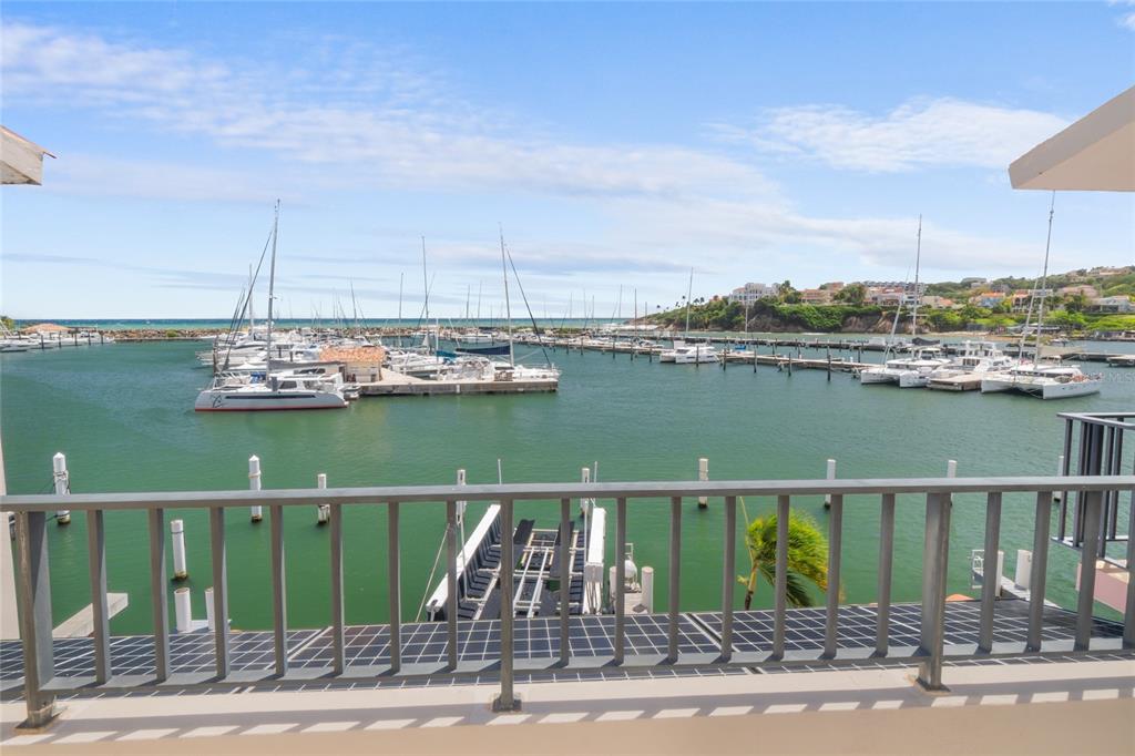 A balcony view overlooking a marina filled with sailboats and yachts under a blue sky — 69 ISLA SAN MIGUEL, HUMACAO, PR