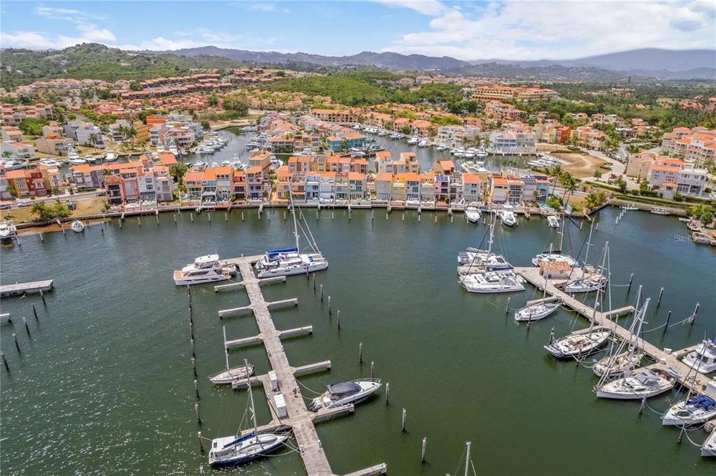 An aerial view of a marina with docked boats and colorful waterfront residential buildings — 69 ISLA SAN MIGUEL, HUMACAO, PR