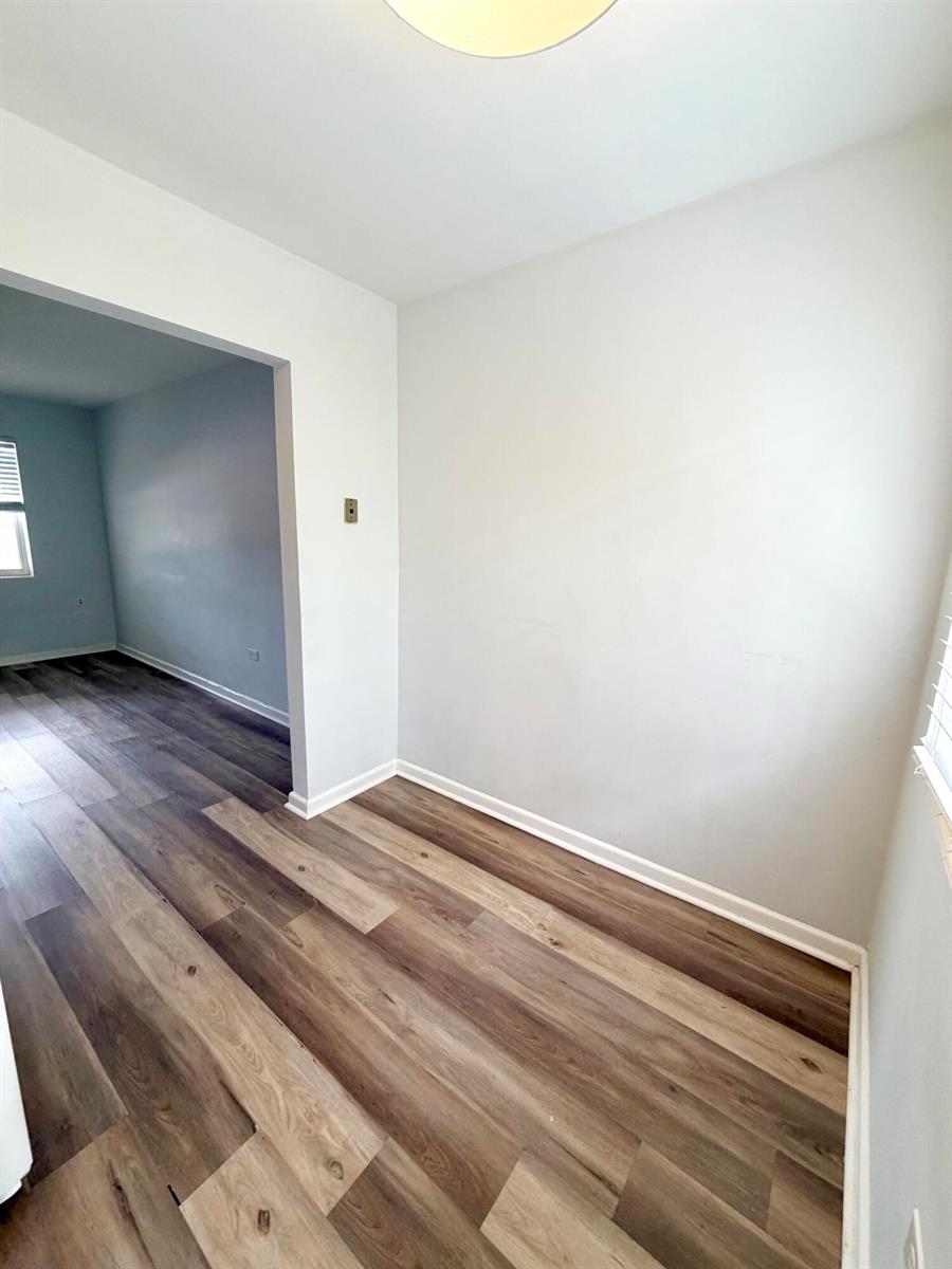 An empty room with light gray walls and wood-look vinyl plank flooring — 1502 N J Street # 2, FL 33460, FL
