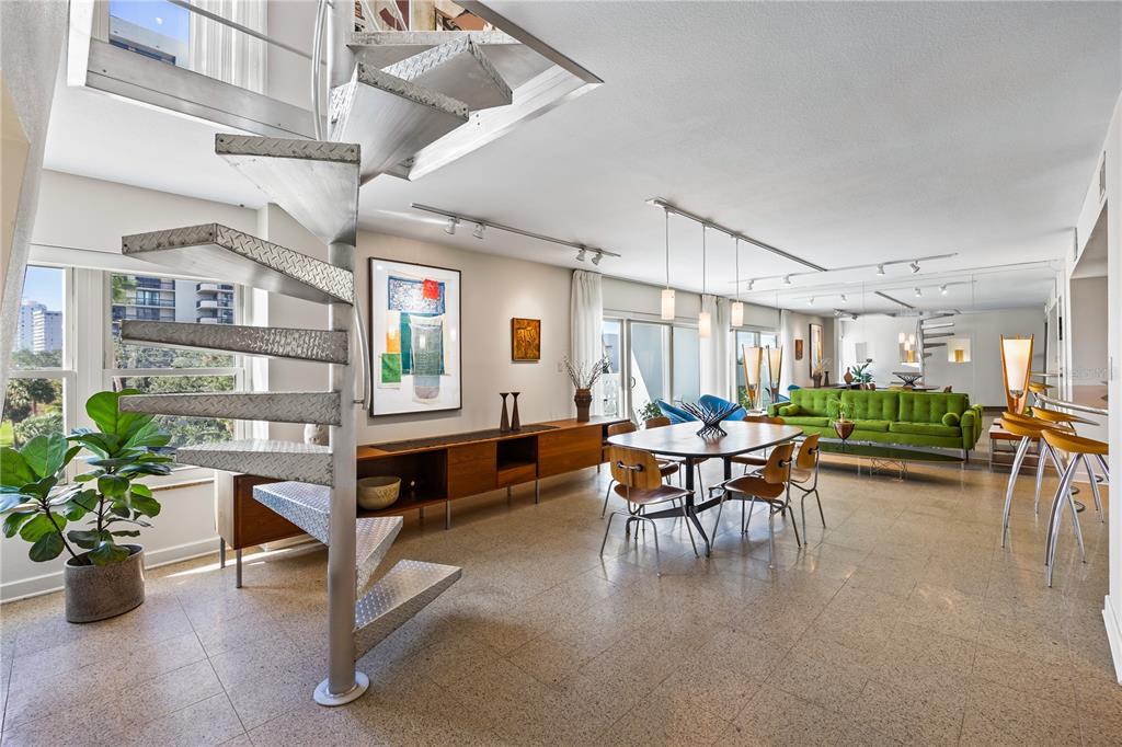 A modern living and dining area features a metal spiral staircase and terrazzo flooring — 2401 BAYSHORE BOULEVARD UNIT 410 & 510, TAMPA, FL