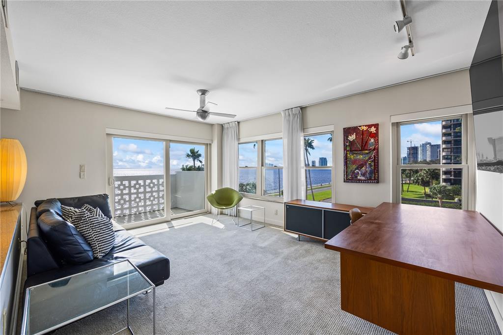 A living room with a dark leather sofa, a wooden desk, and views of water — 2401 BAYSHORE BOULEVARD UNIT 410 & 510, TAMPA, FL