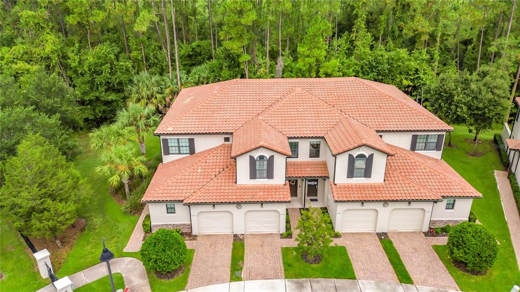 An aerial view of a two-story townhouse with a red tile roof and four garages — 8223 ROSEVILLE ROAD, DAVENPORT, FL