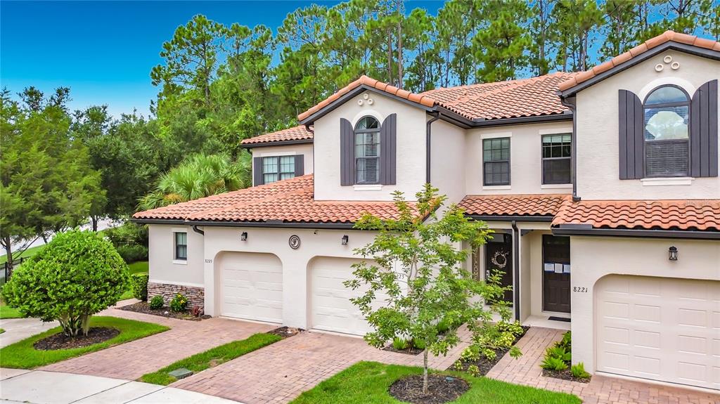 A two-story house with a tile roof, two garage doors, and dark shutters — 8223 ROSEVILLE ROAD, DAVENPORT, FL