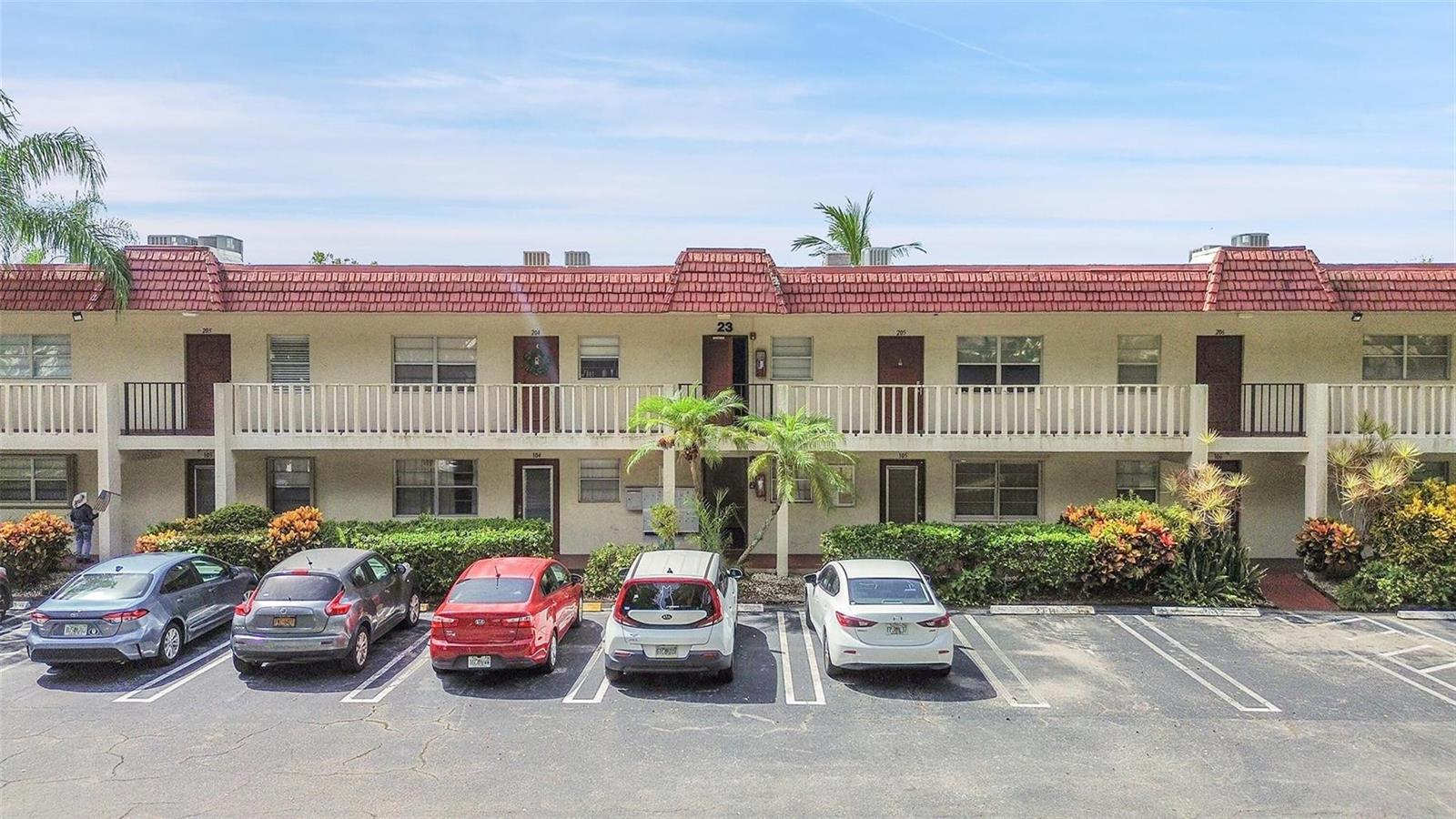 A two-story apartment building with a red tile roof and a parking lot in front — 23 Abbey Lane # 202, Delray Beach FL 33446, DELRAY BEACH, FL