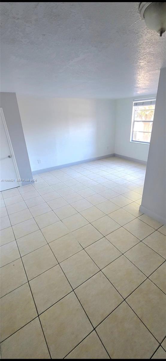 An empty room features light-colored floor tiles, white walls, and a single window — 1805 W 56th St # 209, Hialeah FL 33012, HIALEAH, FL