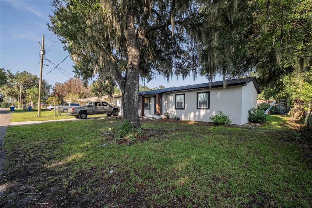 A single-story house with a metal roof and a large oak tree in the yard — 801 N CLERMONT AVENUE, FORT MEADE, FL