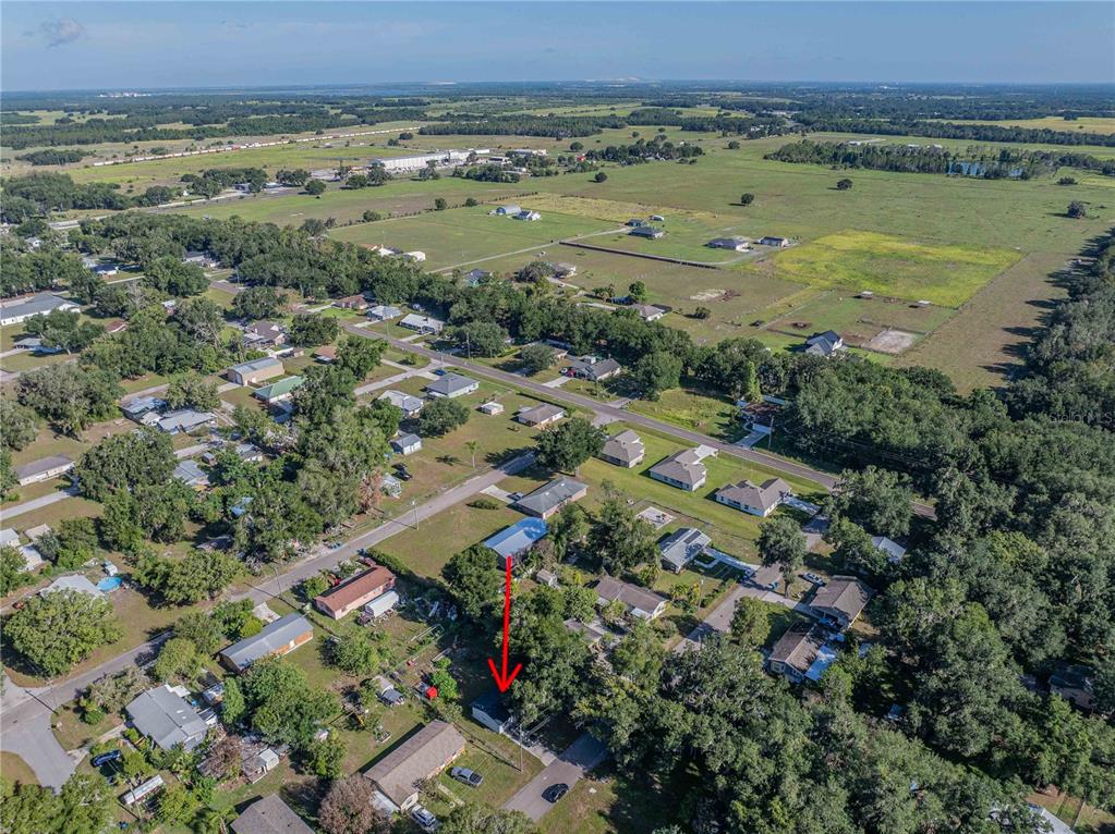 An aerial view shows a residential neighborhood with a red arrow pointing to a house — 801 N CLERMONT AVENUE, FORT MEADE, FL