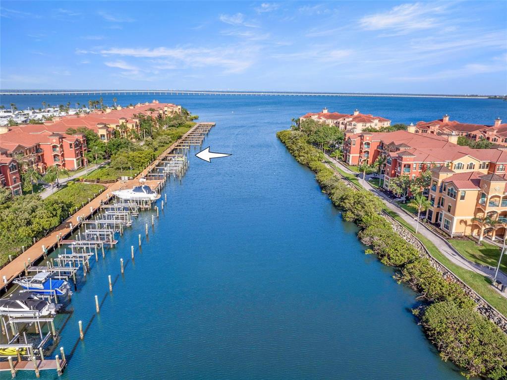 An aerial view shows a narrow canal lined with boat docks and residential buildings — 2765 VIA CIPRIANI UNIT 1232A, CLEARWATER, FL