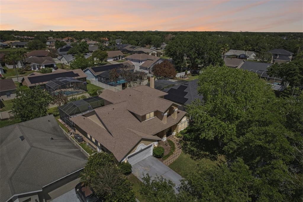 An aerial view shows a two-story suburban house with a brown roof and pool enclosure — 3521 MOLONA DRIVE, ORLANDO, FL