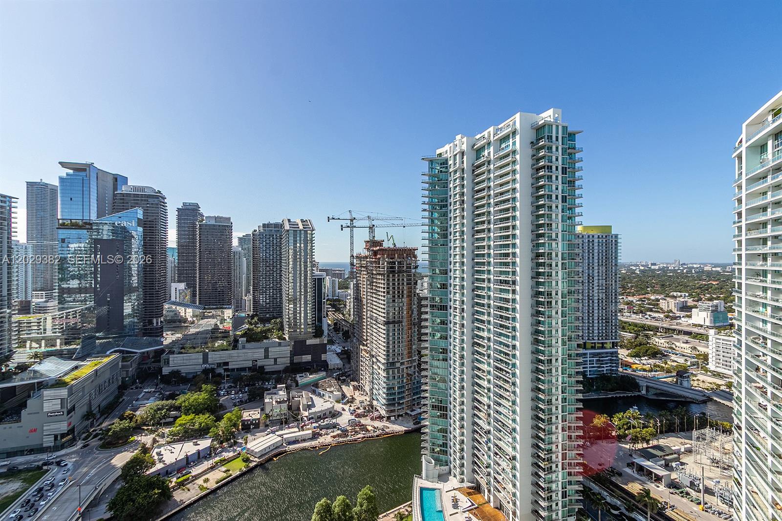 An elevated view of a dense urban skyline featuring multiple high-rise buildings and a river — 350 S Miami Ave # 3914, Miami FL 33130, MIAMI, FL