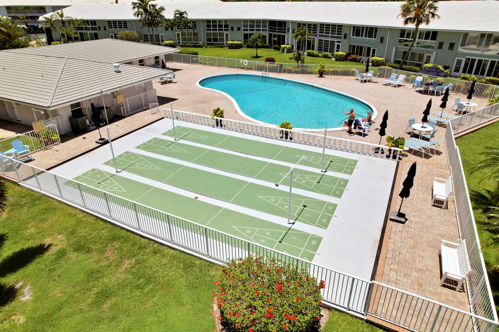 An aerial view of a swimming pool and shuffleboard courts at a residential apartment complex — 5540 N Ocean Boulevard # 206, Ocean Ridge FL 33435, OCEAN RIDGE, FL