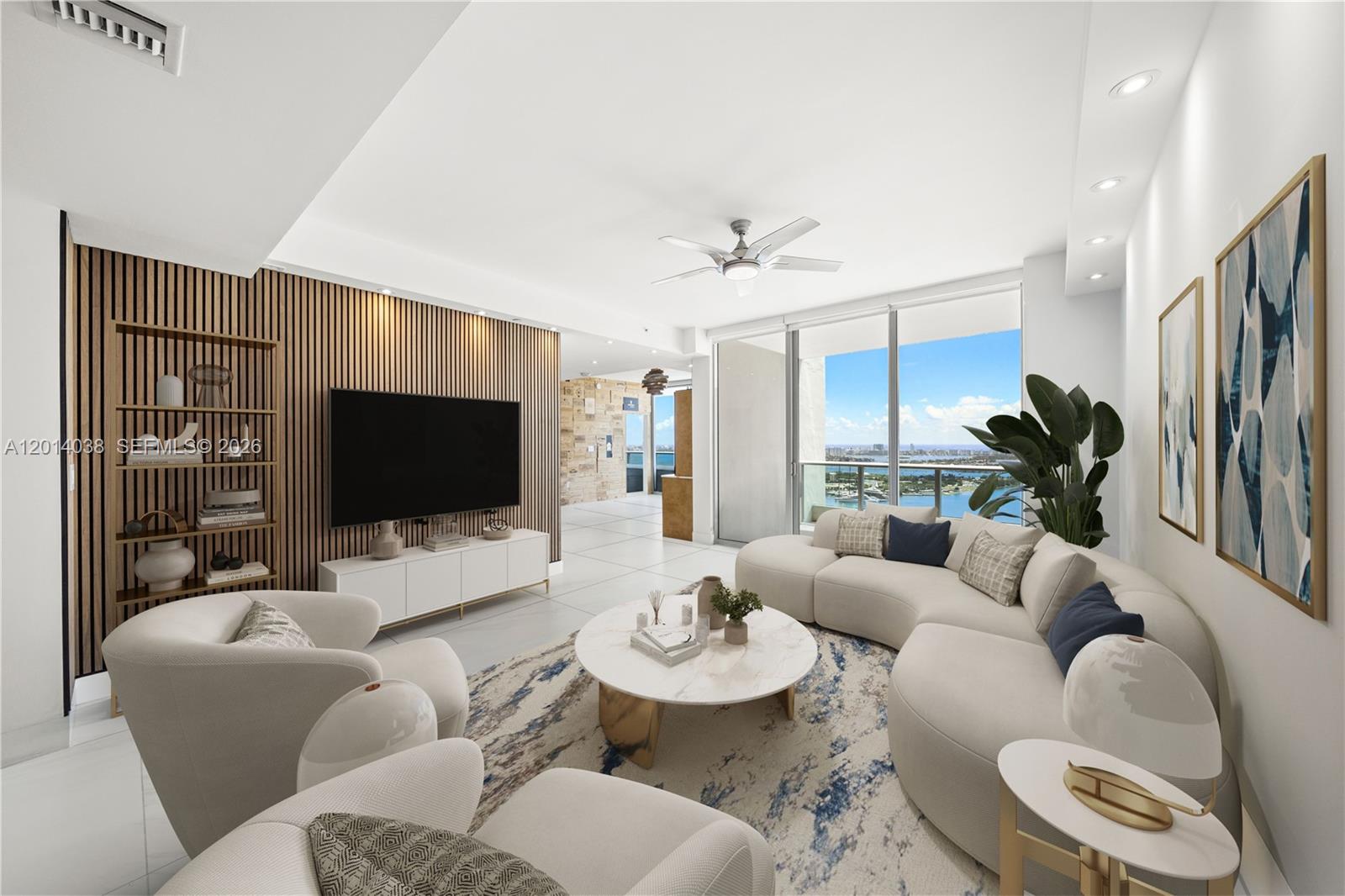 A modern living room features a slatted wood accent wall, curved sofa, and panoramic water views — 900 Biscayne Blvd # 4202, Miami FL 33132, MIAMI, FL
