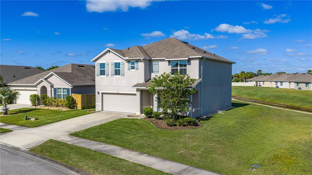 A two-story suburban house with a beige stucco exterior and a two-car garage — 5324 ROYAL PLANTATION BOULEVARD, PORT ORANGE, FL