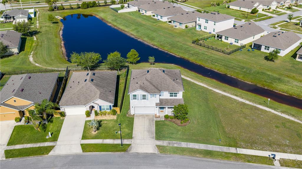 An aerial view shows two suburban houses with driveways facing a street near a pond — 5324 ROYAL PLANTATION BOULEVARD, PORT ORANGE, FL