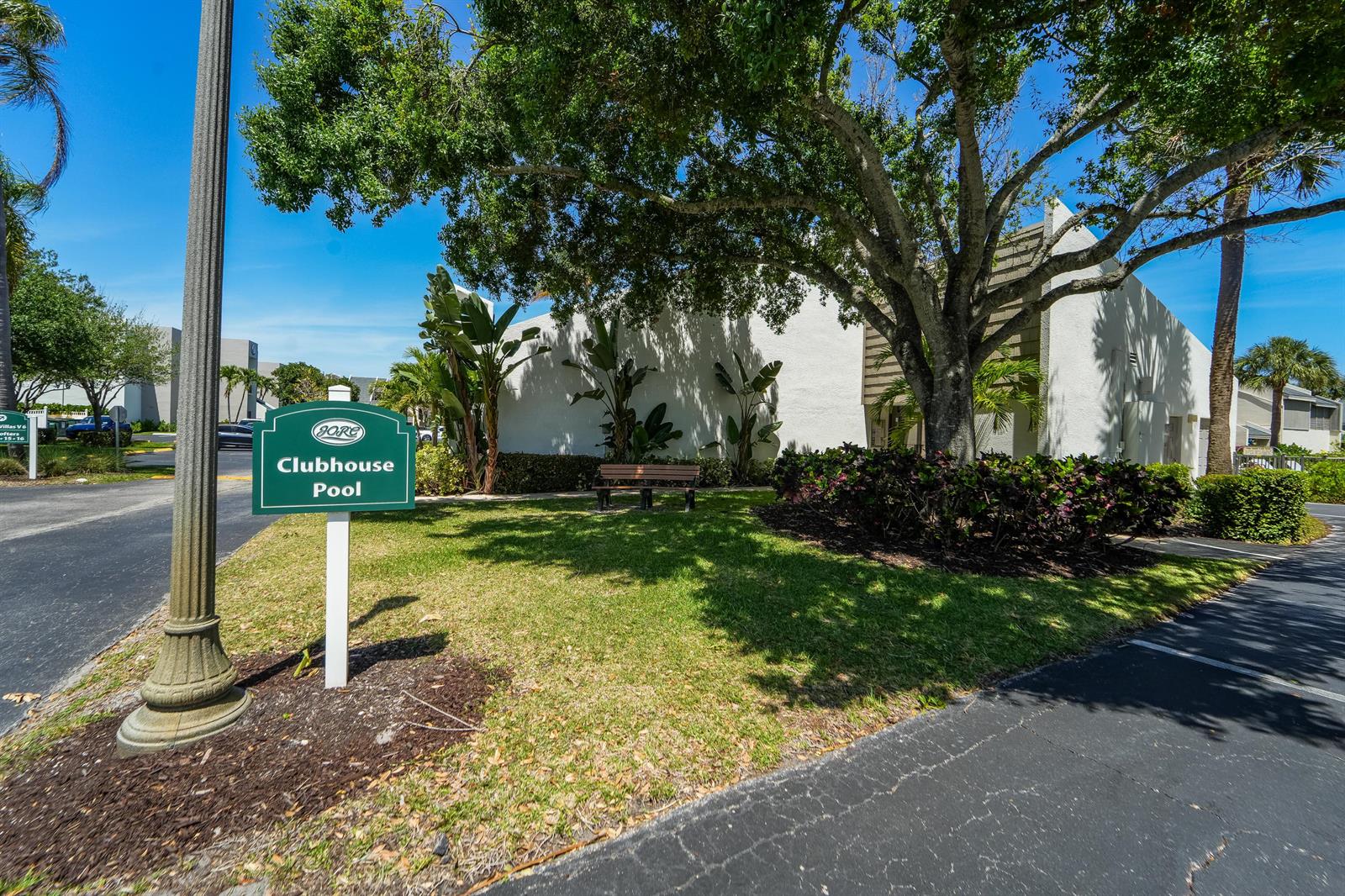 A green sign points toward a clubhouse and pool near a tree and bench — 1605 S Us Highway 1, Jupiter FL 33477, JUPITER, FL