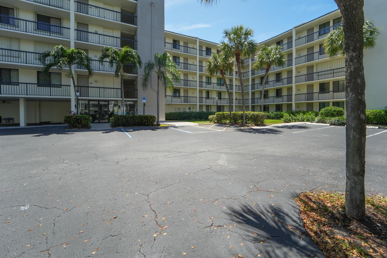An exterior view of a multi-story apartment building with a parking lot and palm trees — 1605 S Us Highway 1, Jupiter FL 33477, JUPITER, FL