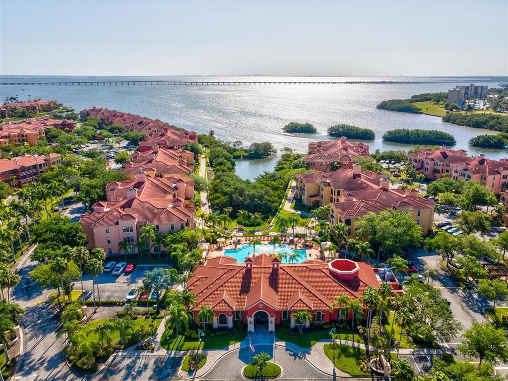 An aerial view of a waterfront apartment complex with a pool and red-tiled roofs — 2731 VIA CAPRI UNIT 925, CLEARWATER, FL