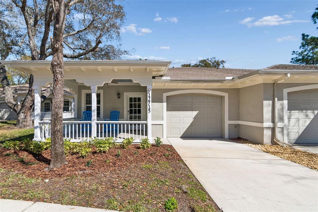 A single-story house features a covered front porch, a concrete driveway, and a garage — 12715 TAYLOR NICOLAS DRIVE, TAMPA, FL