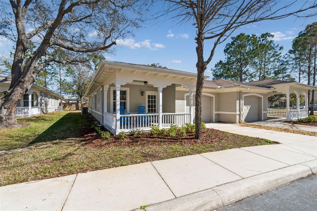 A single-story house with a front porch, white railing, and an attached garage — 12715 TAYLOR NICOLAS DRIVE, TAMPA, FL