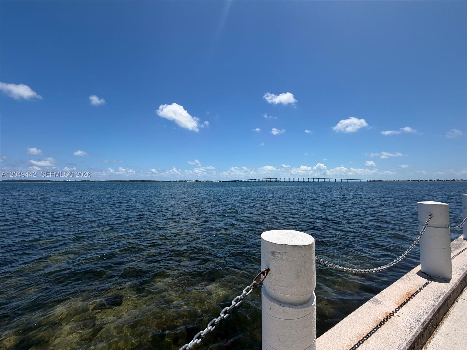 A view of the ocean from a concrete pier with white bollards and chains — 1420 Brickell Bay Dr # 1005C, Miami FL 33131, MIAMI, FL