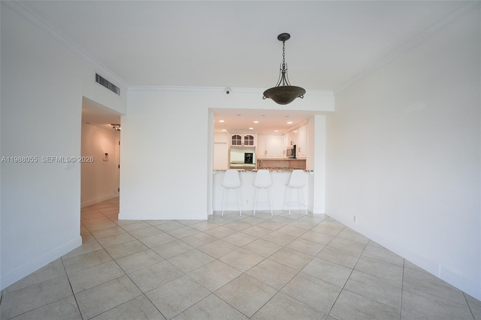 A dining area with tile floors leads to a kitchen featuring a breakfast bar — 151 Crandon Blvd # 320, Key Biscayne FL 33149, KEY BISCAYNE, FL