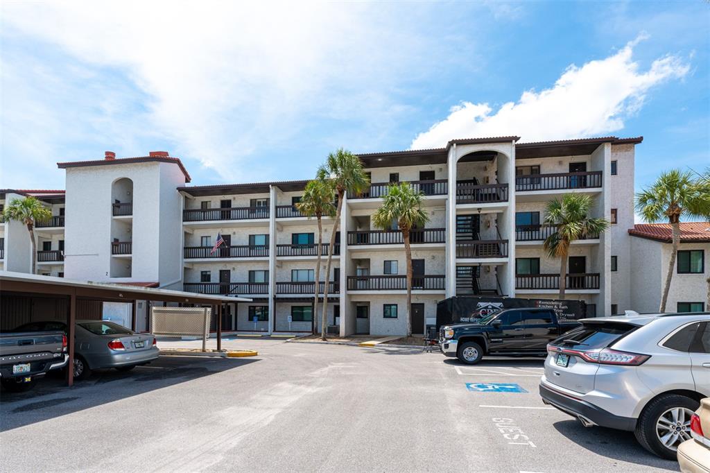 A multi-story apartment building with balconies and a parking lot in the foreground — 1608 STICKNEY POINT ROAD UNIT 1608-204, SARASOTA, FL