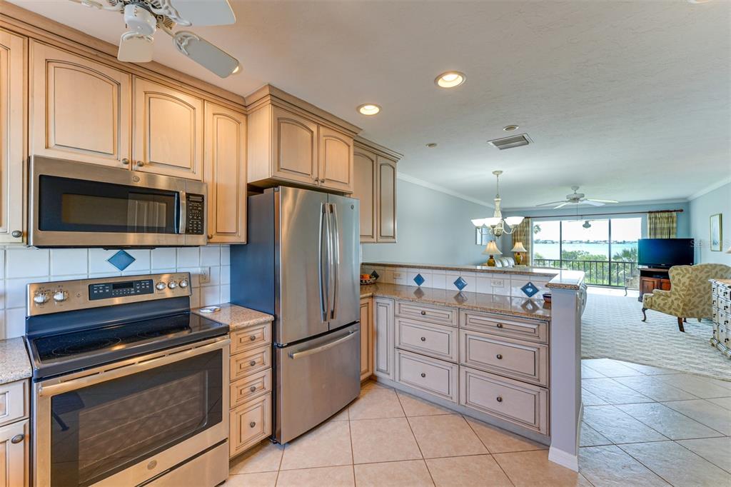 A kitchen with stainless steel appliances, light wood cabinets, and a view of the water — 1608 STICKNEY POINT ROAD UNIT 1608-204, SARASOTA, FL