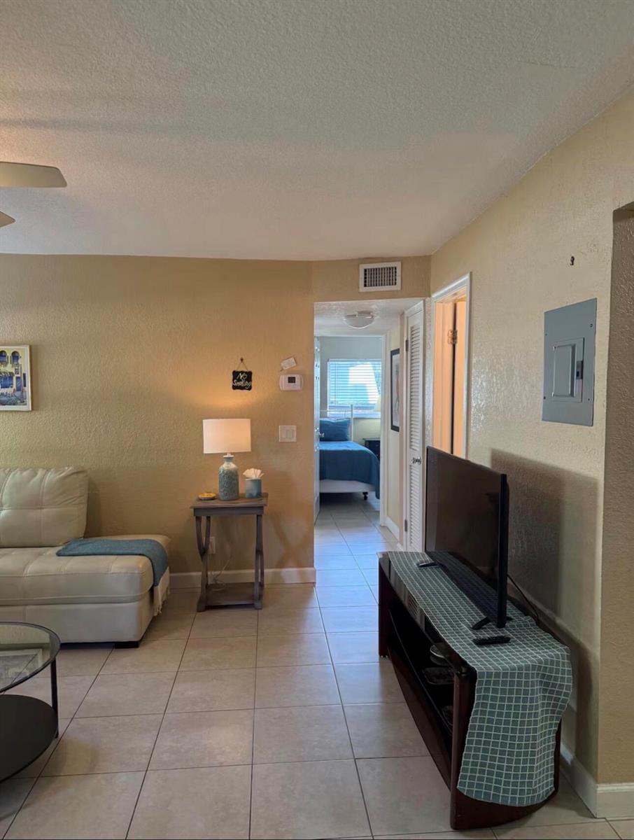 A living room with tile floors, a white sofa, and a view into a bedroom — 211 S Swinton Avenue, Delray Beach FL 33444, DELRAY BEACH, FL