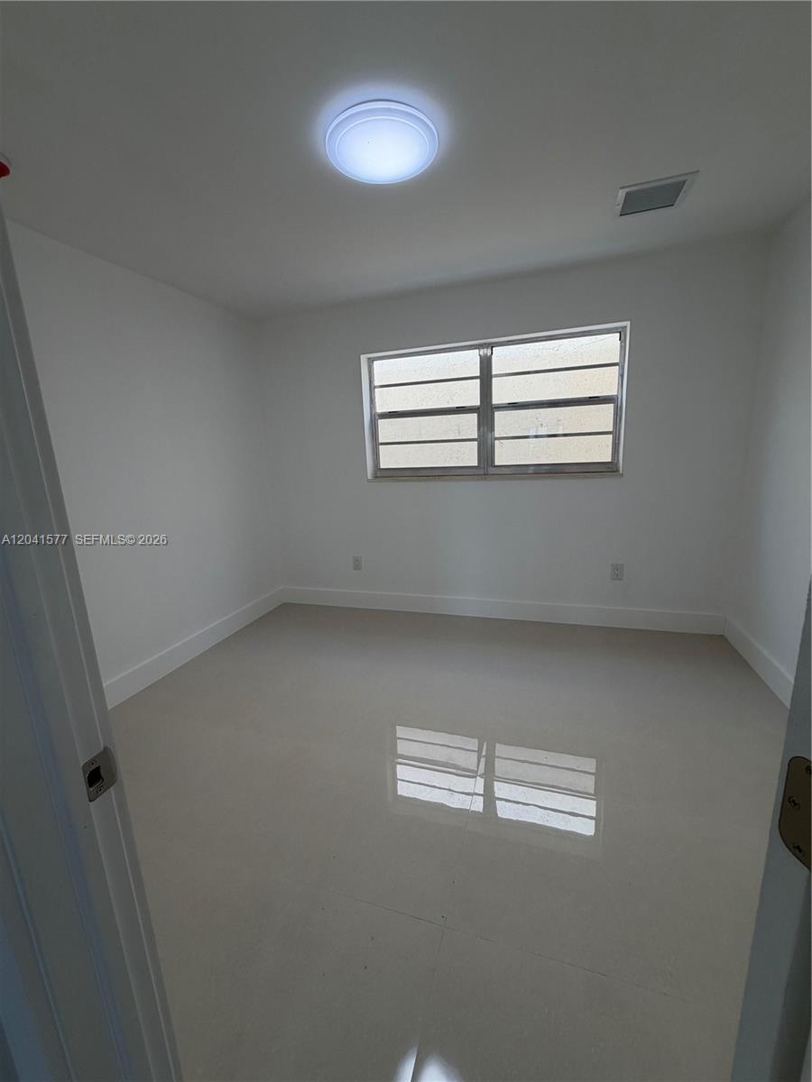 An empty room features white walls, a tiled floor, and a single window — 1551 W Okeechobee Rd # 3, Hialeah FL 33010, HIALEAH, FL