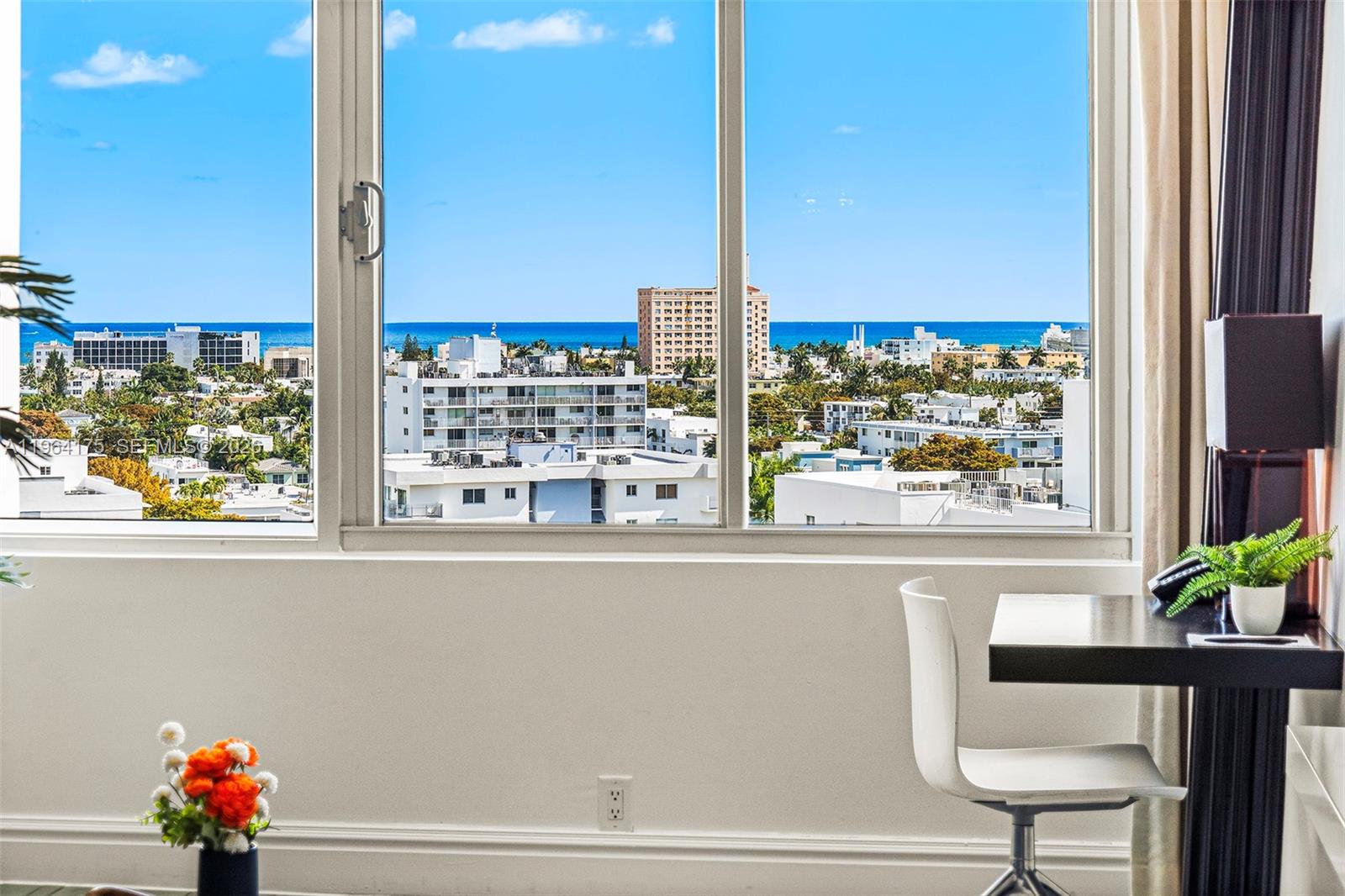 A view of a city skyline and ocean through a large window in a room — 1100 West Ave # 1123, Miami Beach FL 33139, MIAMI BEACH, FL