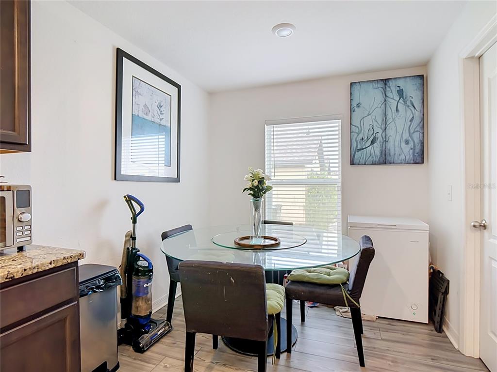 A dining area features a glass-topped table, four chairs, and a chest freezer — 1741 CANAAN LOOP, DUNDEE, FL