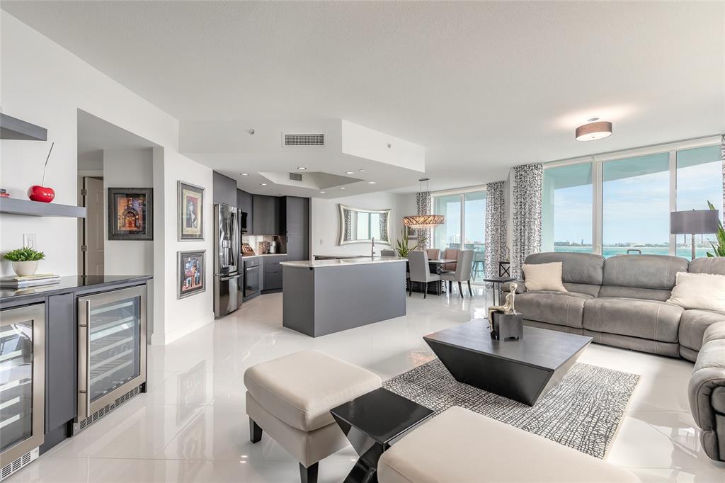 A modern open-concept living room and kitchen with gray cabinetry, tile floors, and ocean views — 241 RIVERSIDE DRIVE UNIT 701, HOLLY HILL, FL