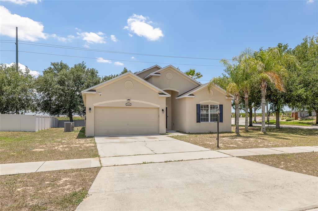 A single-story beige house with a two-car garage and a concrete driveway — 3216 LYNROCK AVENUE, DUNDEE, FL