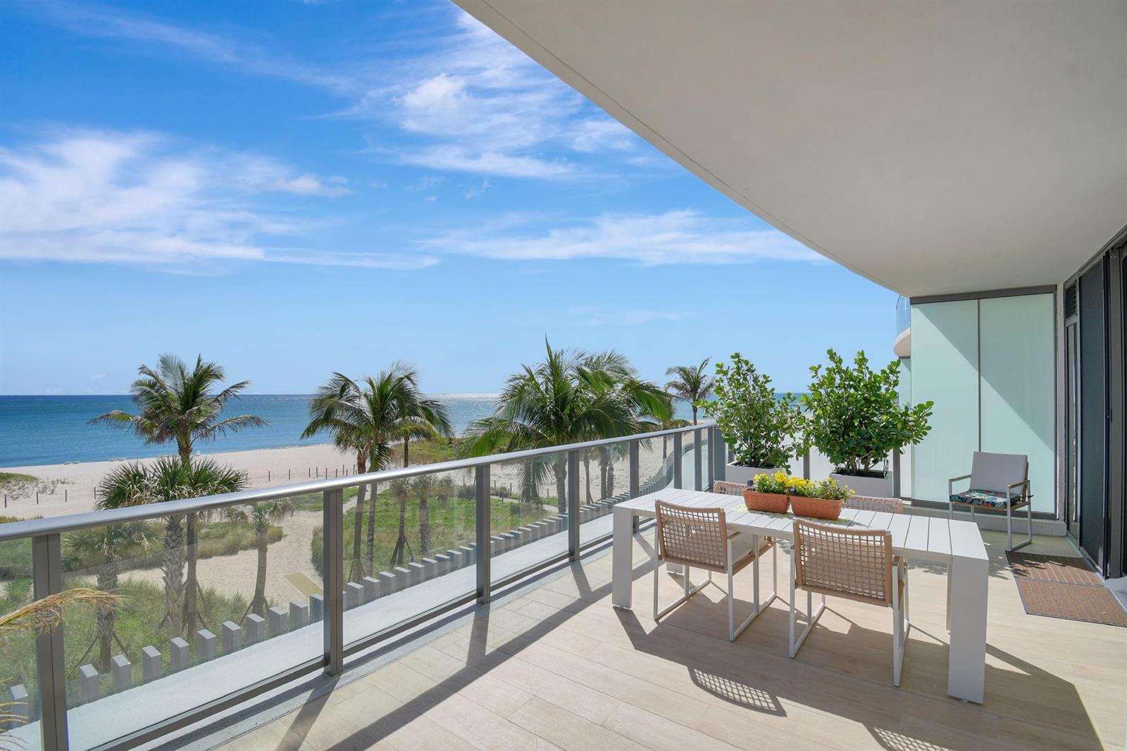 A balcony with a dining set overlooks a sandy beach and the ocean — 1116 N Ocean Boulevard # 303, Pompano Beach FL 33062, POMPANO BEACH, FL
